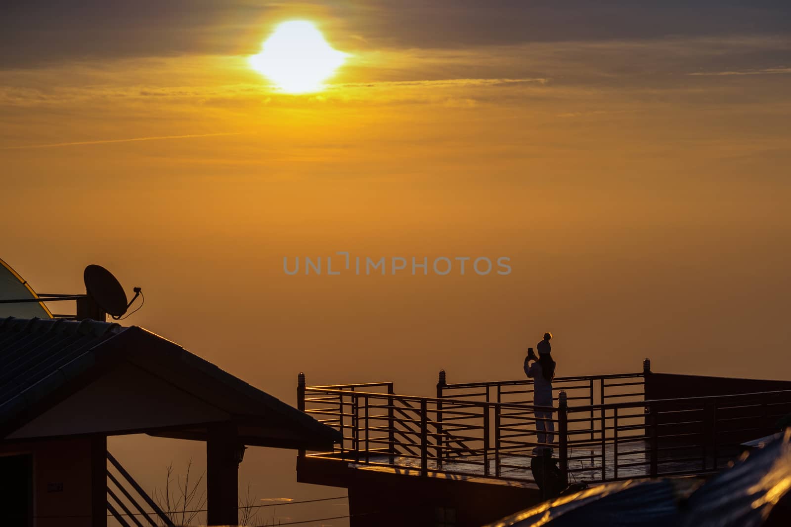 Woman taking photos of sunrise. by gutarphotoghaphy