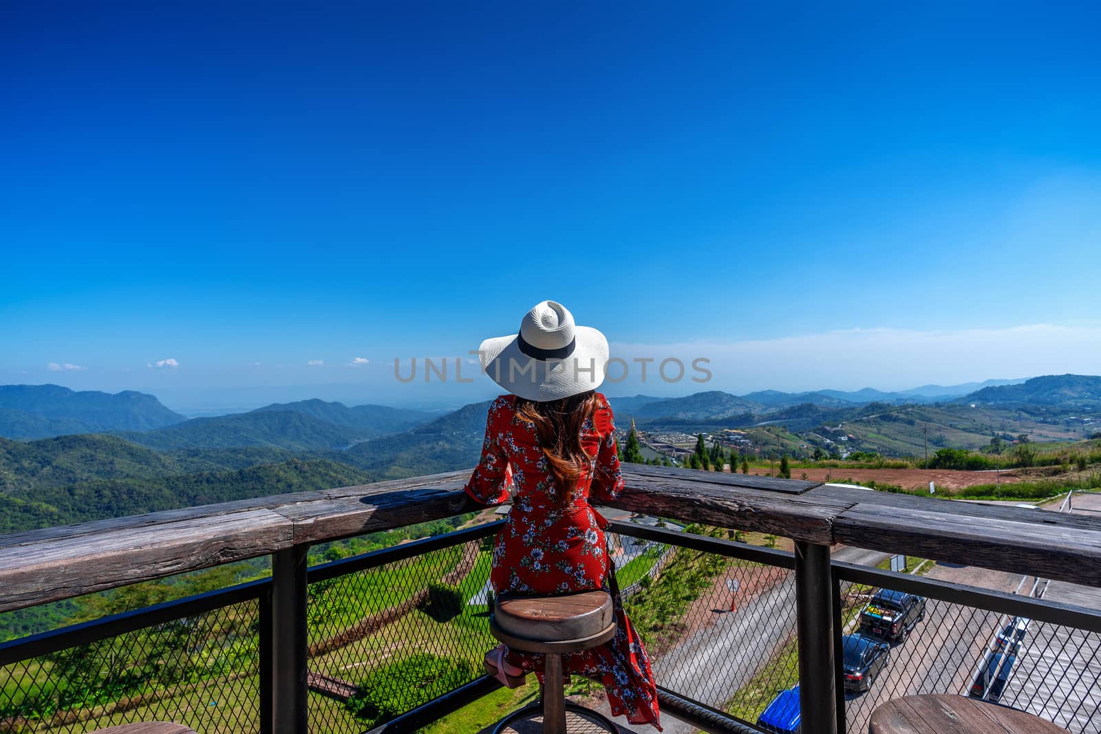 Young woman sitting on the deck and looking to nature landscape, Thailand