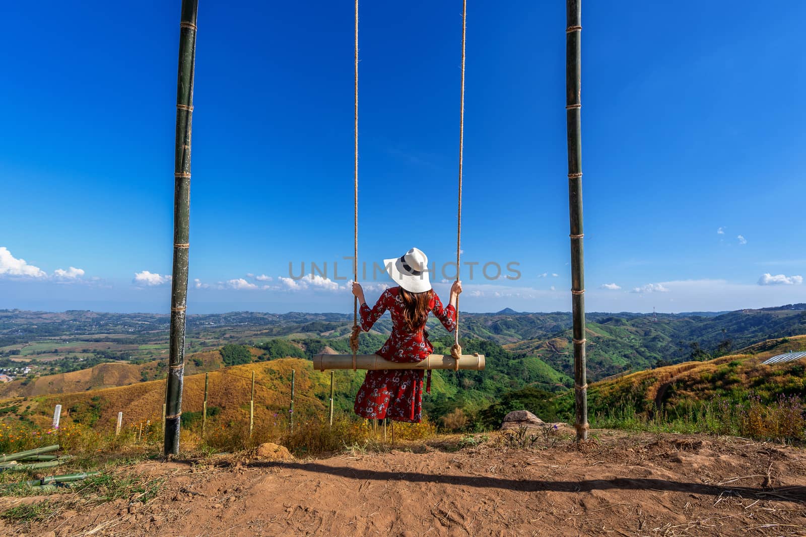 Young woman sitting on a swing and looking to nature. by gutarphotoghaphy
