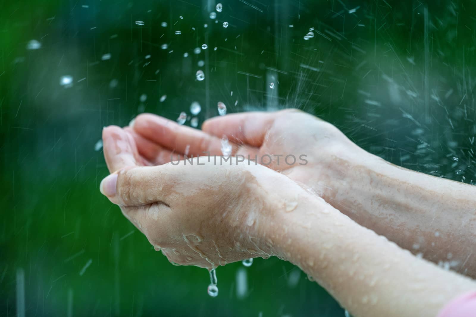 Close-up of wet female hands in rain by gutarphotoghaphy