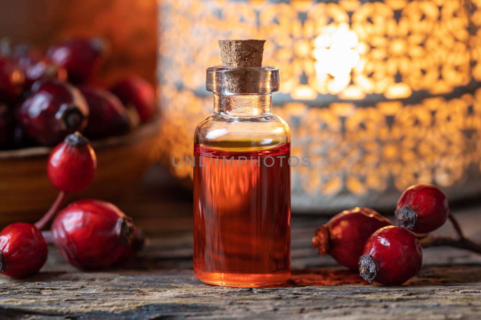 A bottle of rose hip seed oil with dried berries