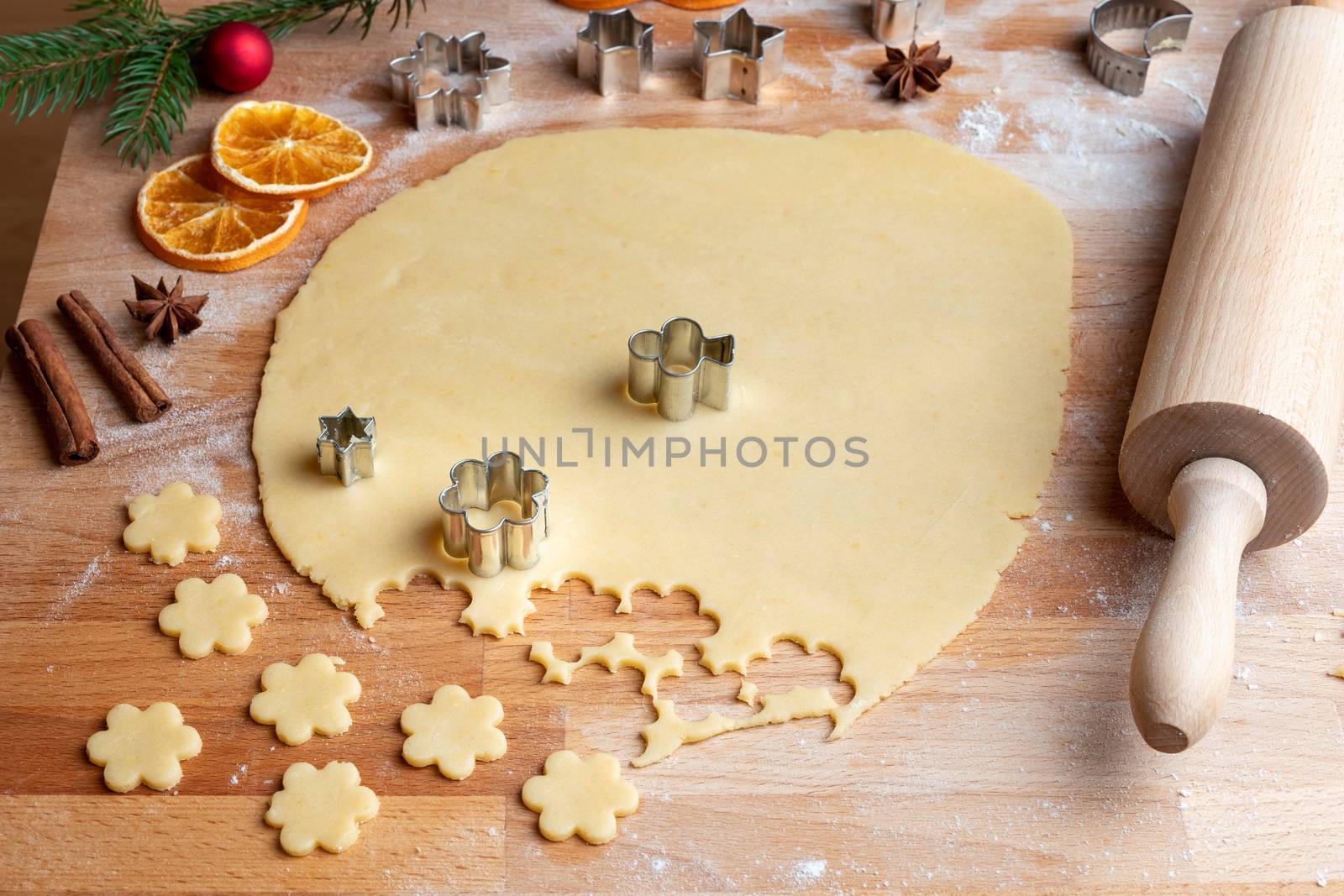 Cutting out shapes from rolled out dough to prepare traditional Linzer Christmas cookies