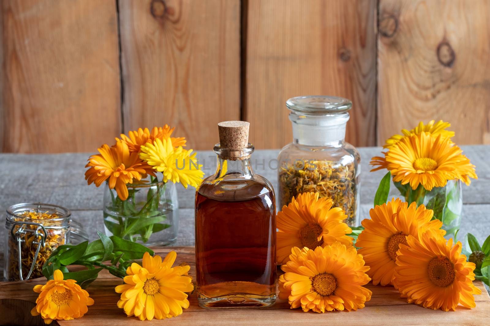 A bottle of calendula tincture with fresh flowers