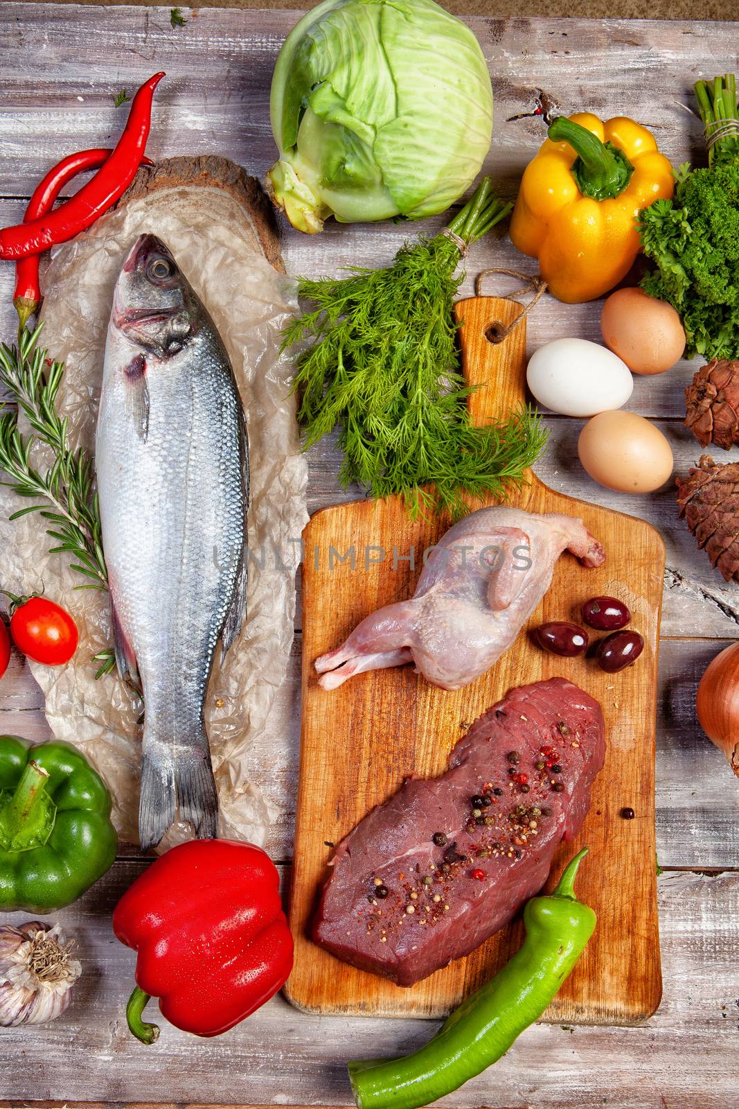 Chicken, fish and vegetables on an old wooden desk