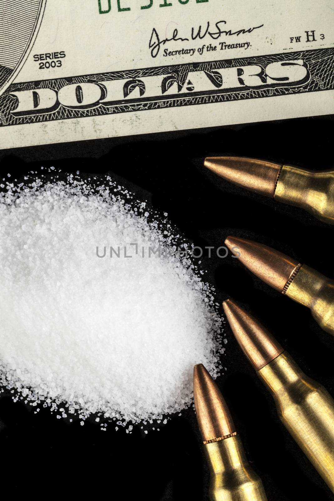 bullets with dollar banknotes with white drug powder on black background