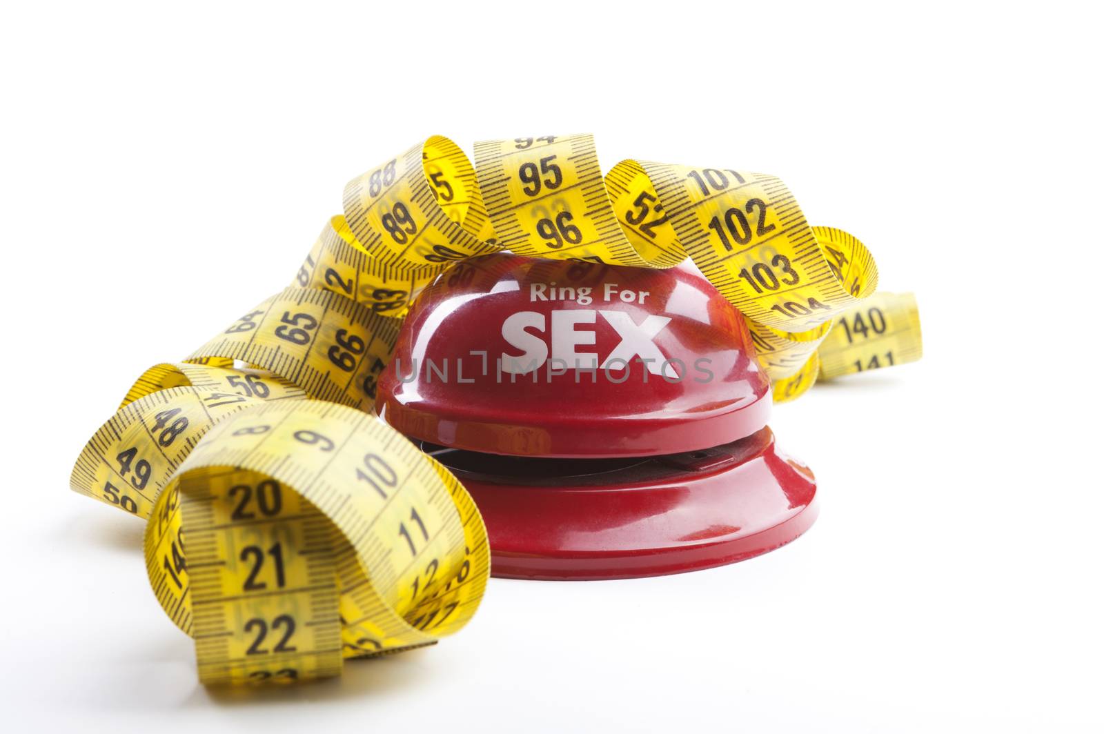 Red Ring for sex bell close-up with yellow measuring tape  isolated on white background