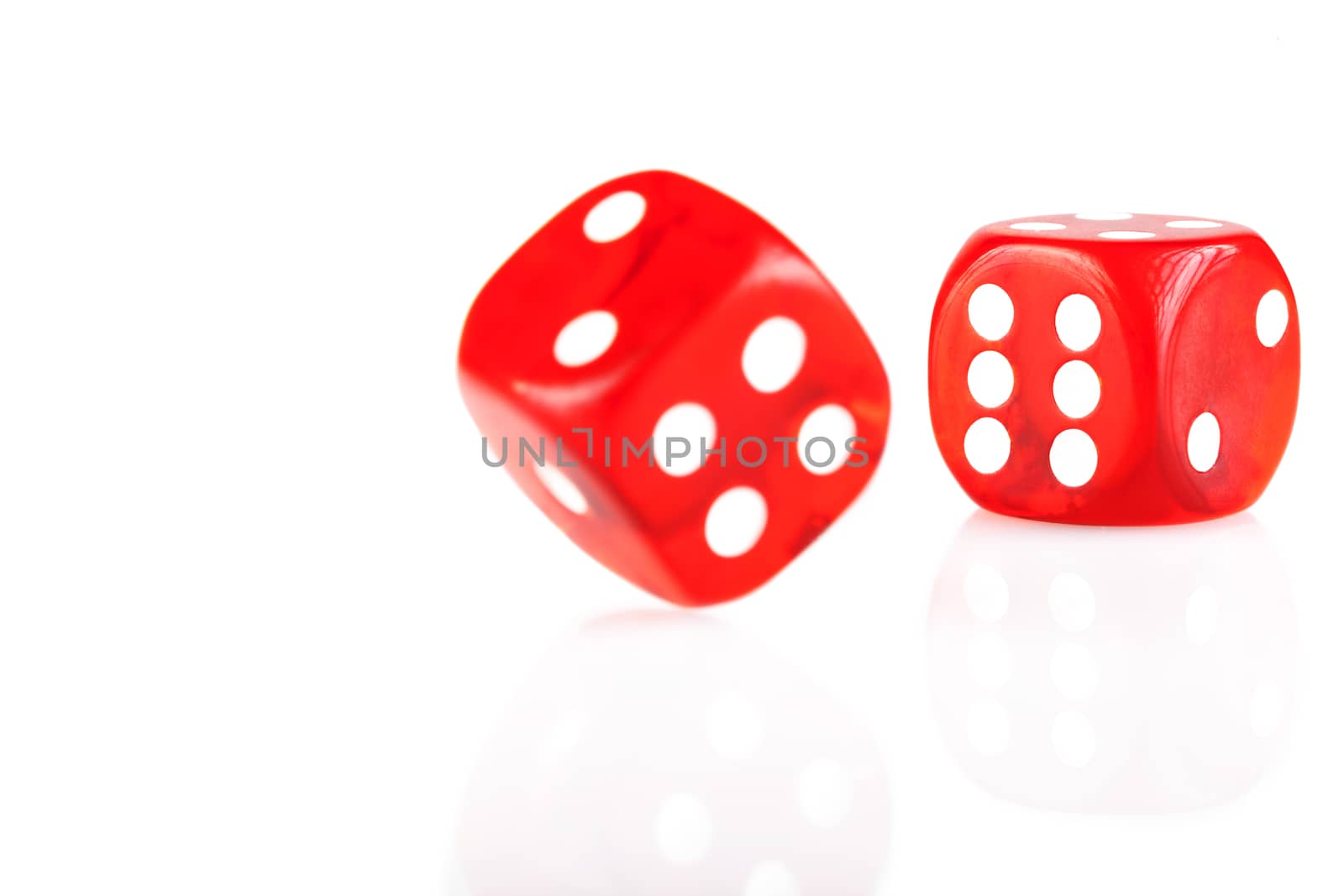 Pair of red dice isolated on white background with reflection