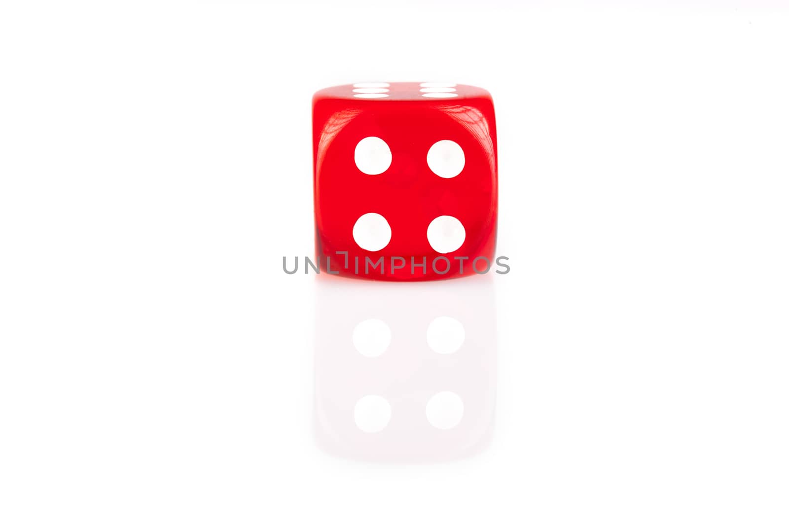 One red dice isolated on white background with reflection