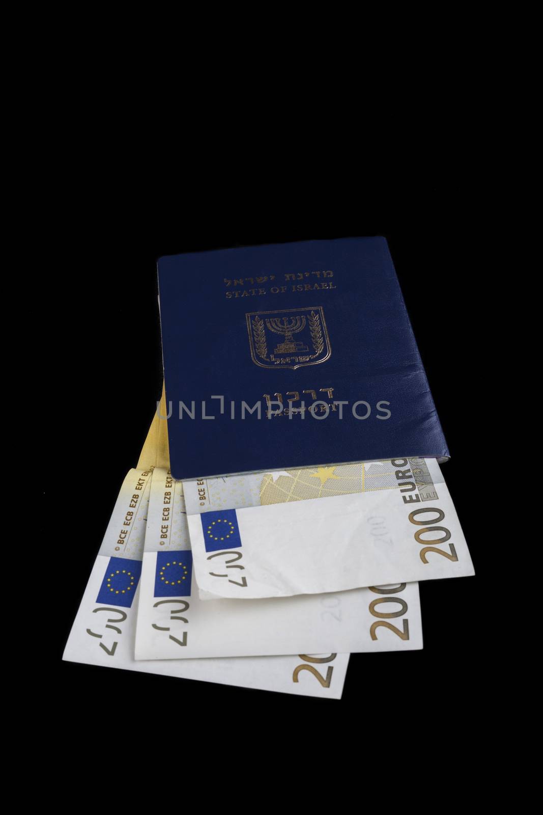 Israelian passport with 200 euro banknotes isolated on black