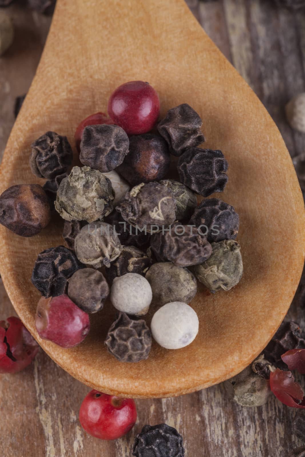Various type of peppers on wood spoon and old wood table macro close-up