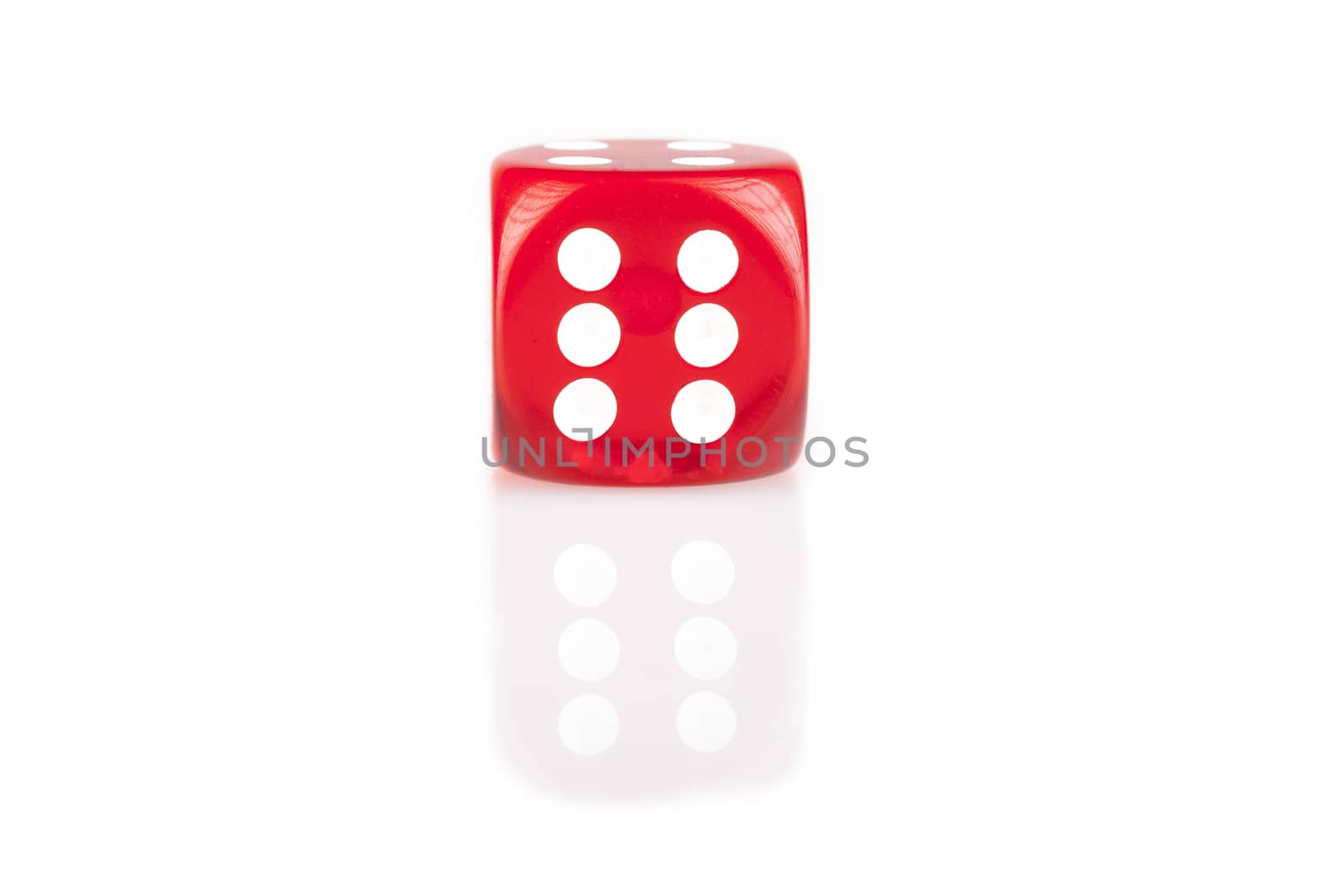 One red dice isolated on white background with reflection