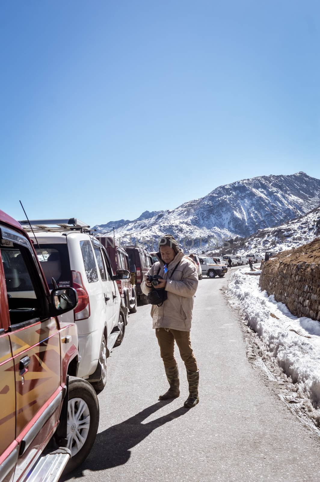 Traffic jam and Highway blockage due to snowfall at Tsomgo Lake. Tourist vehicles lined up to climb in step hill region of himalayan mountain valley. by sudiptabhowmick