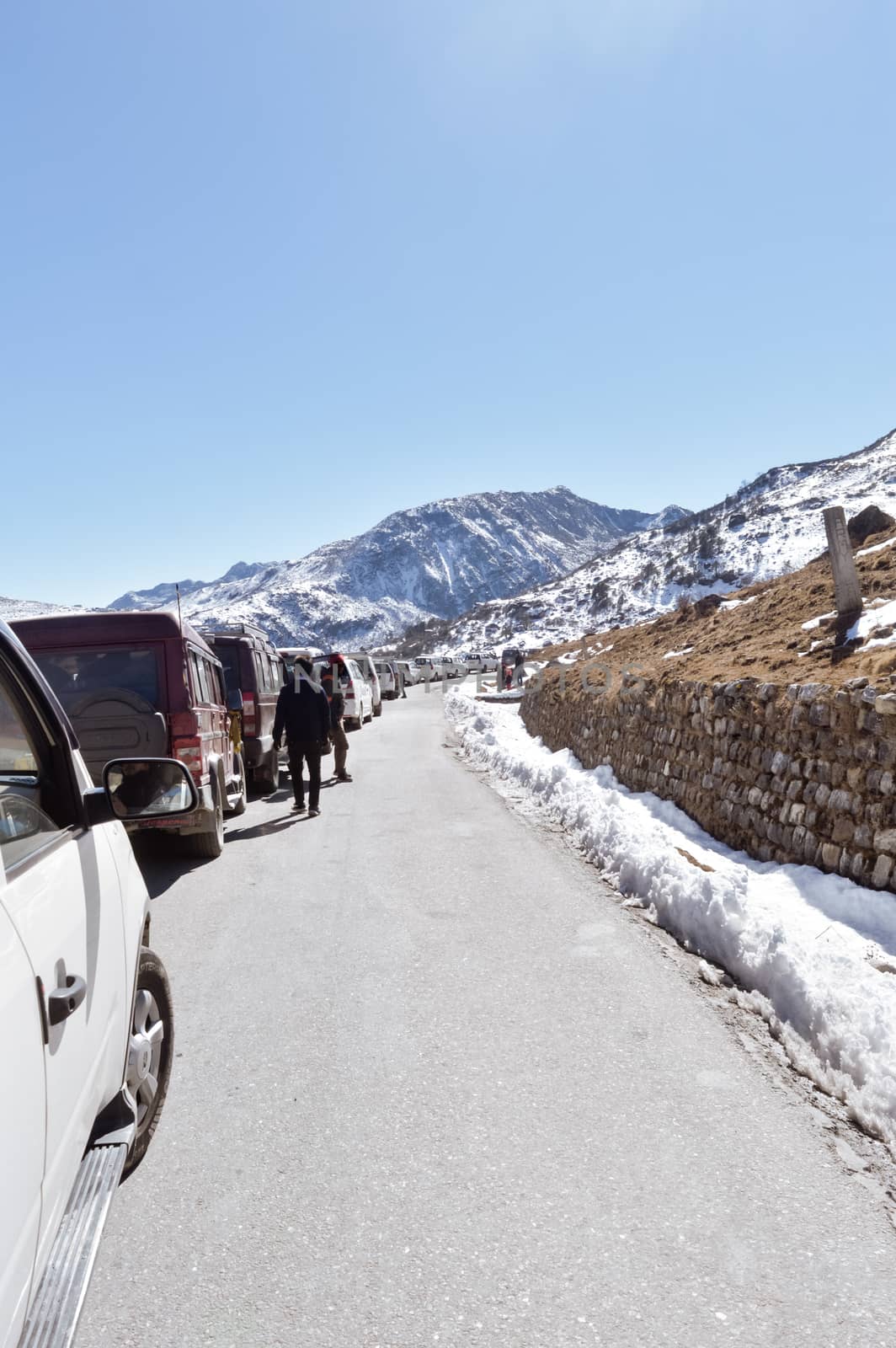 Traffic jam and Highway blockage due to snowfall at Tsomgo Lake. Tourist vehicles lined up to climb in step hill region of himalayan mountain valley. by sudiptabhowmick