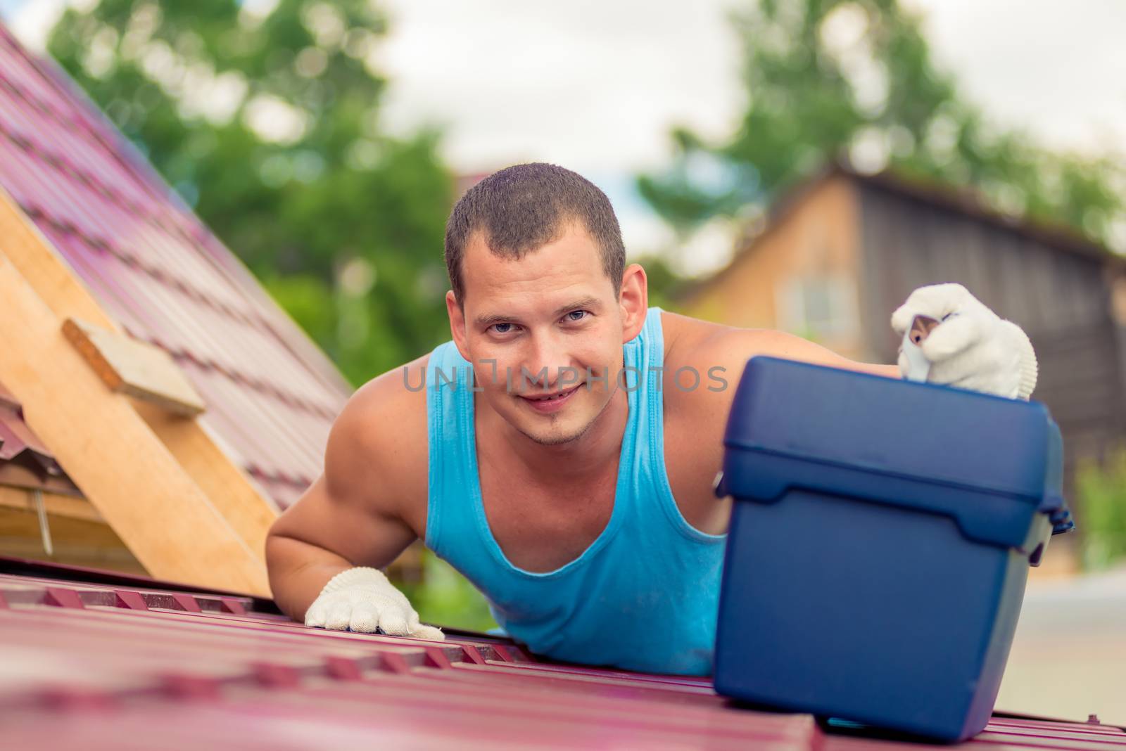 a man with a toolbox on the roof of the house during the repair