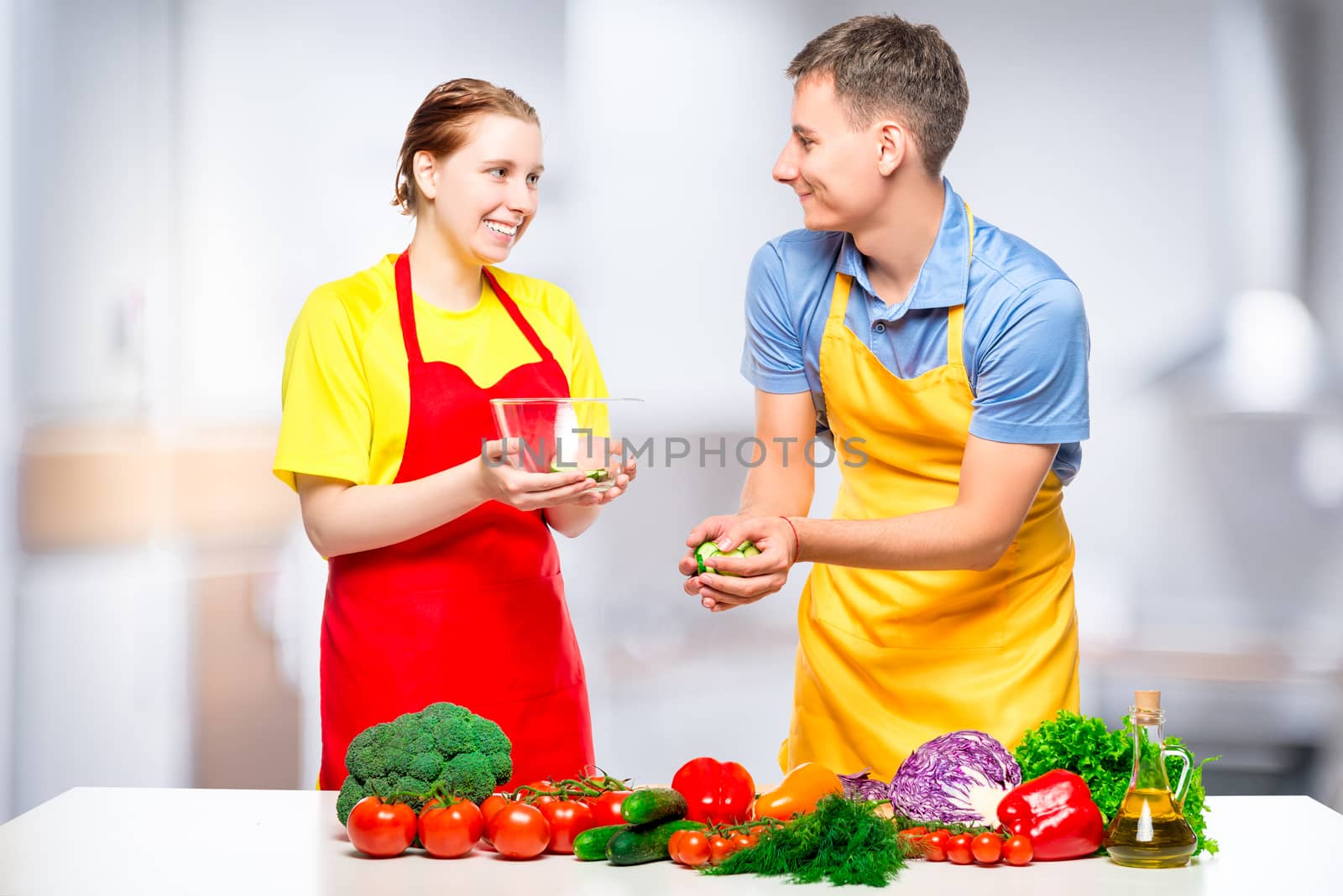 man and woman preparing healthy vegetable salad in the kitchen by kosmsos111