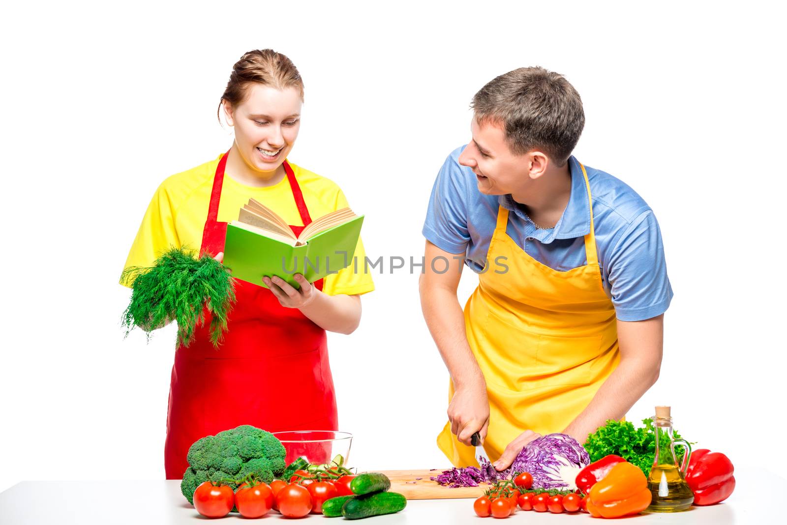 woman with a recipe book, a man cuts vegetables cooked together a salad on a white background