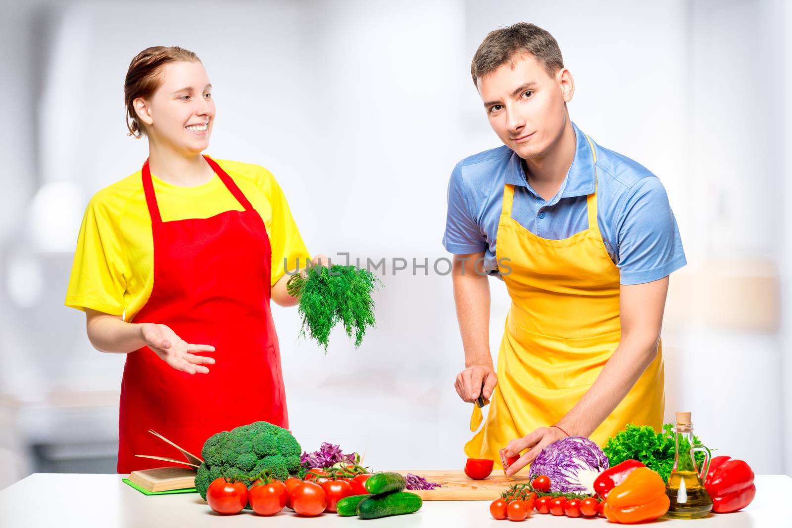 happy couple cooking salad in the kitchen