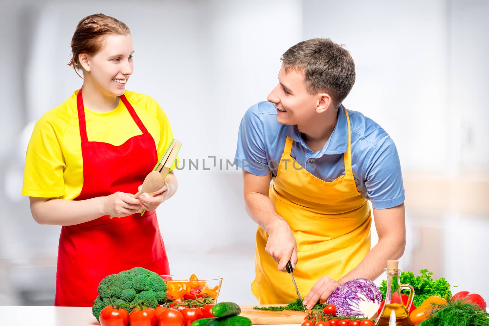 happy couple cooking together healthy and tasty vegetable salad by kosmsos111