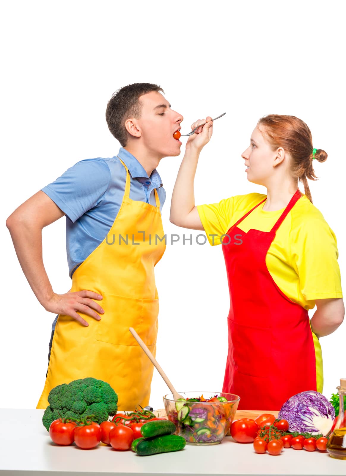 woman with a wooden spoon feeds a man a useful vegetable salad o by kosmsos111