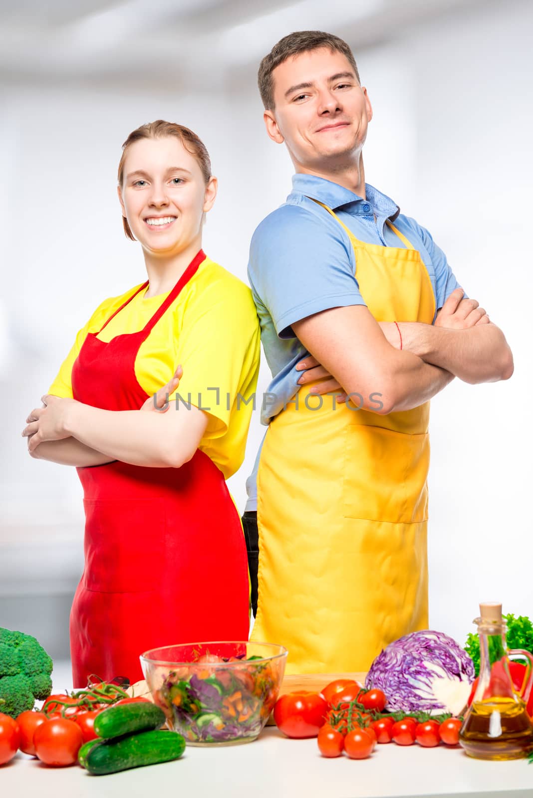 happy man and woman in aprons preparing vegetable salad, portrai by kosmsos111