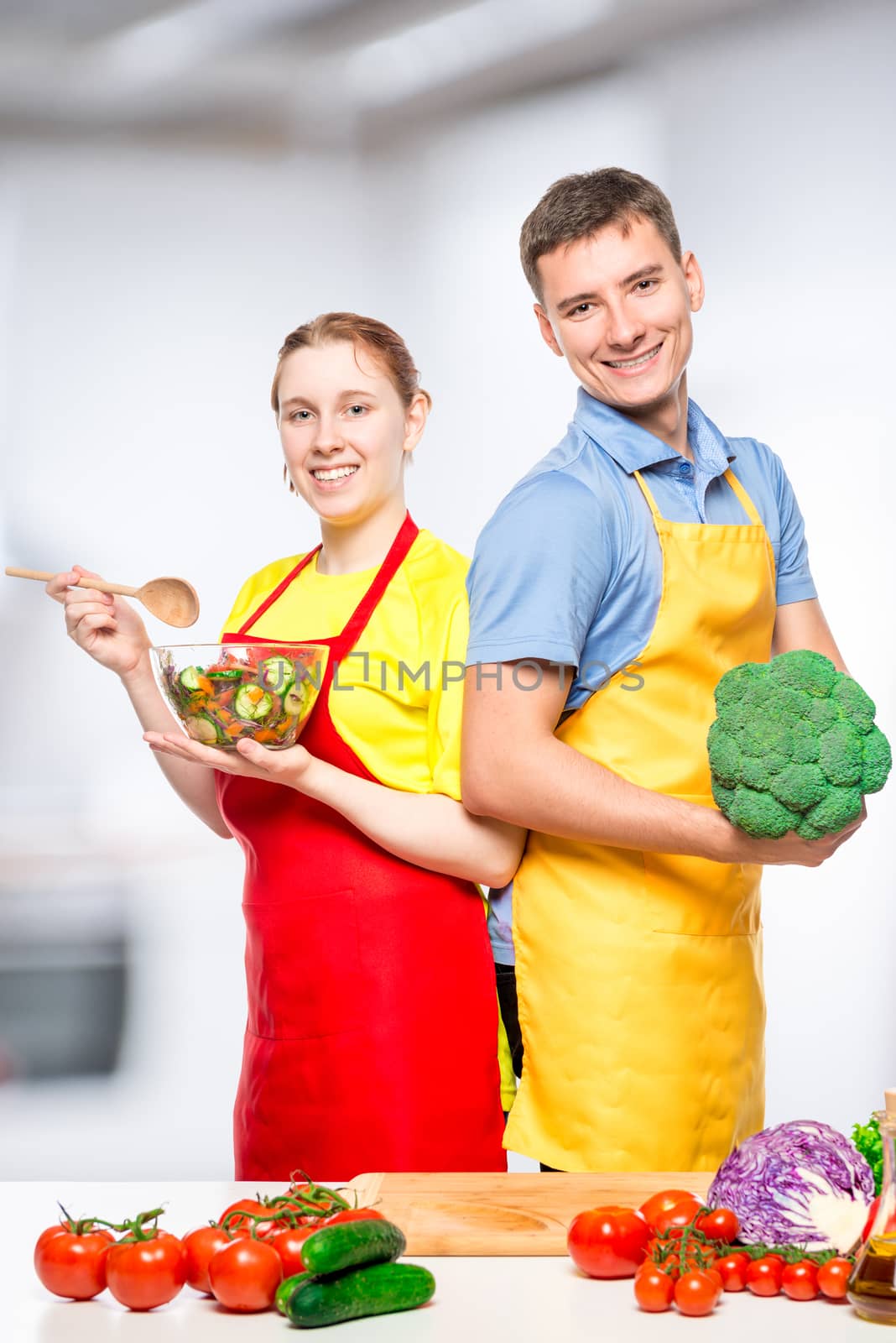 Vertical portrait of a happy couple with vegetables and salad in by kosmsos111
