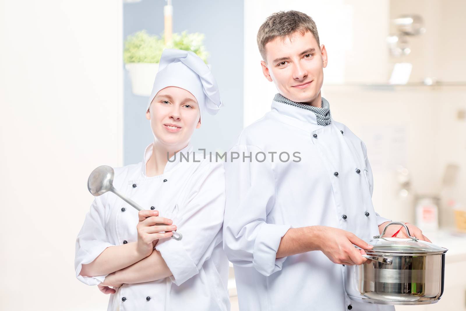 horizontal portrait of a pair of cooks with a pan and a ladle on a white background by kosmsos111