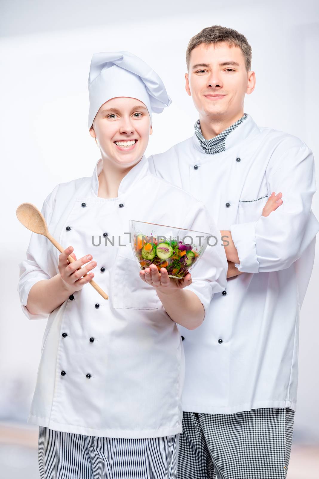 vertical portrait of successful chefs with salad by kosmsos111