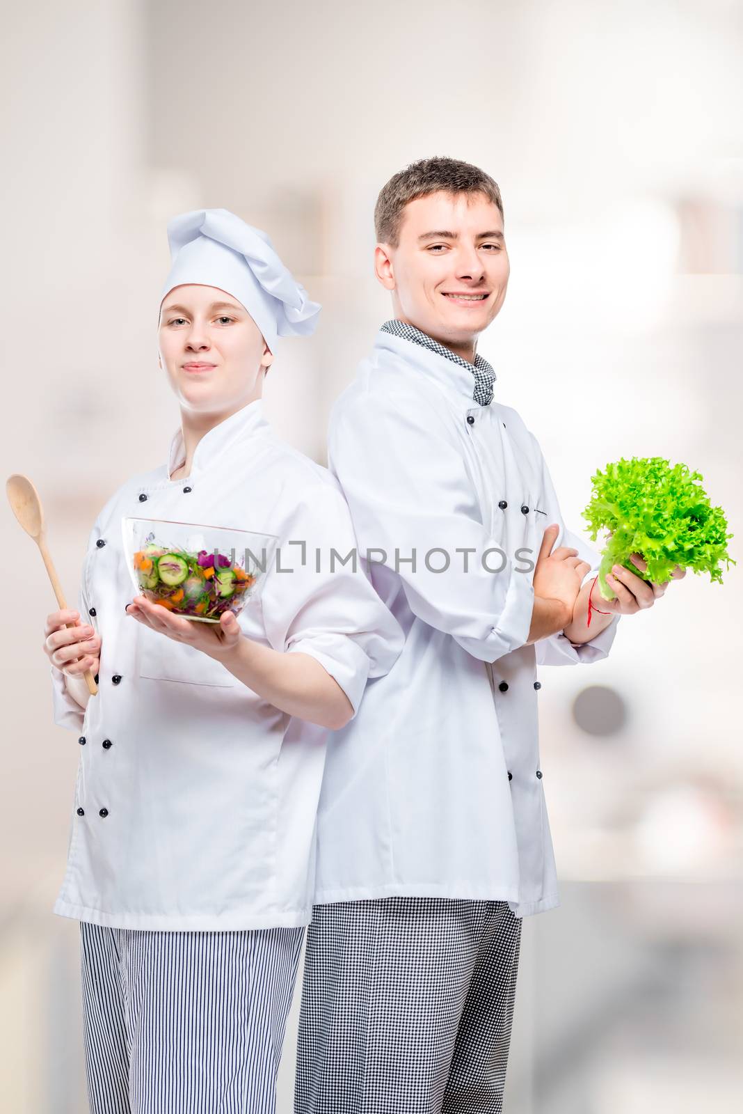 professional happy chefs in suits with a salad in their hands ag by kosmsos111