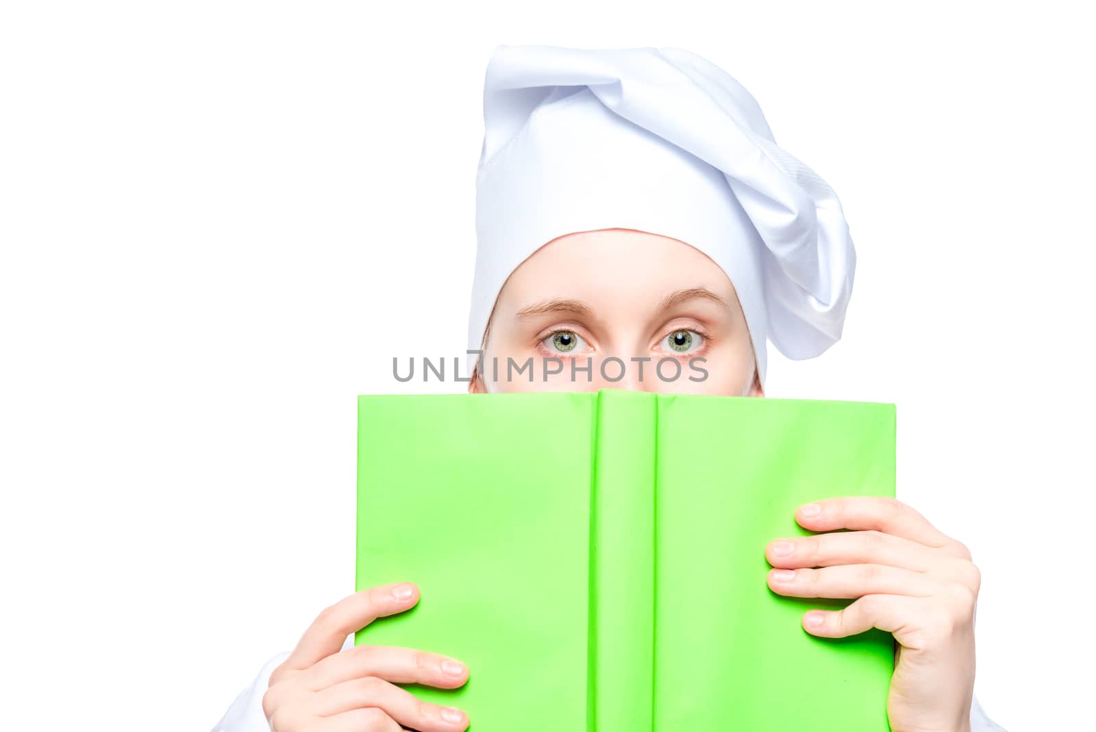 portrait of a cook in a cap close-up, face covered with a book of recipes concept photo isolated on white background