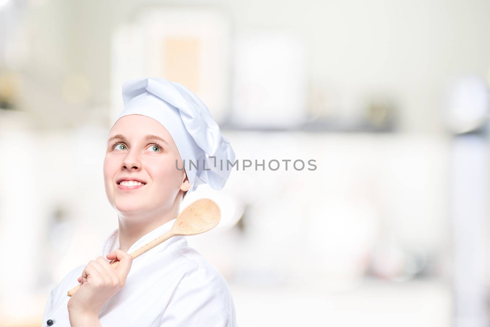 portrait of a happy dreaming cook with a wooden spoon, a place for an inscription on the right