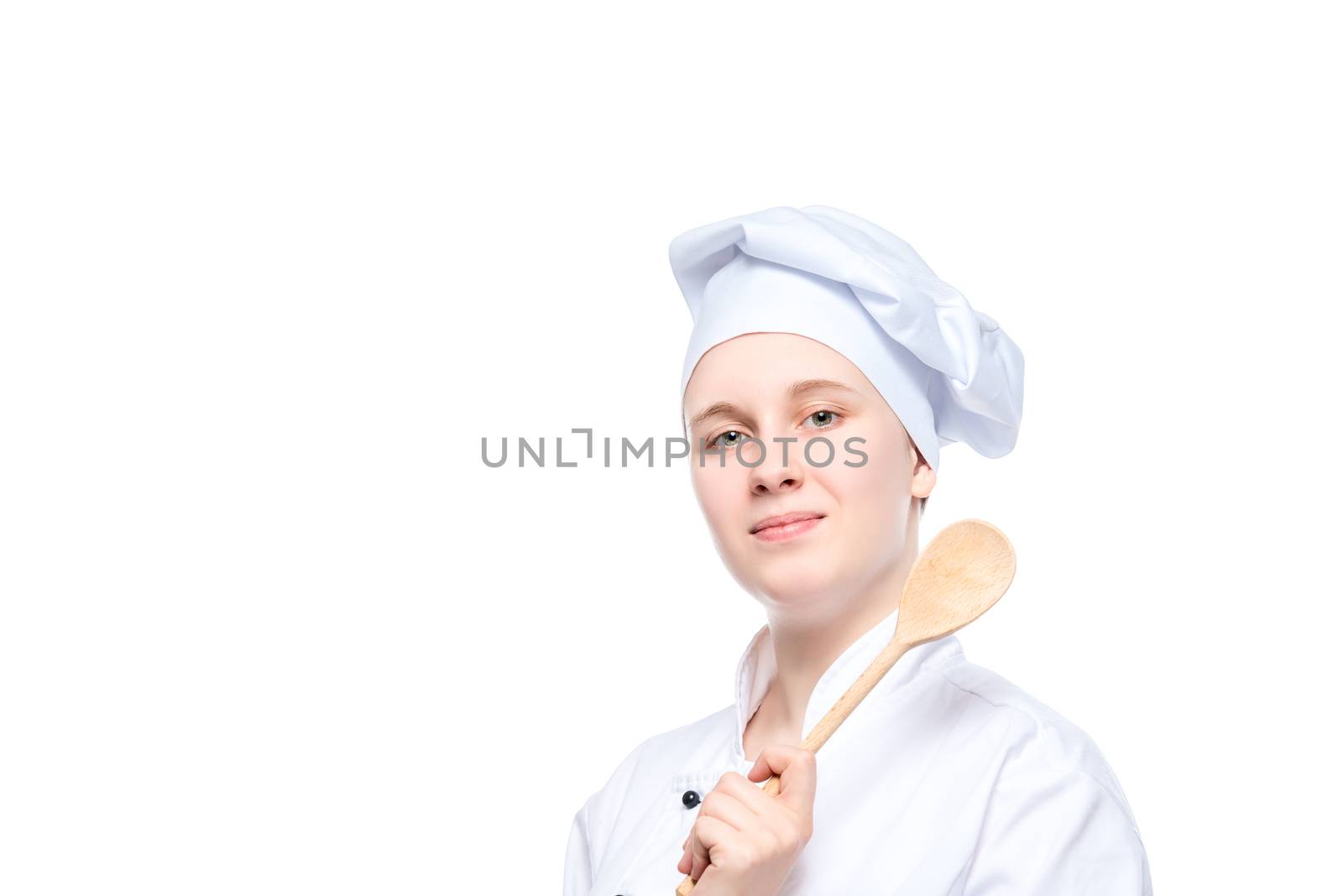 isolated portrait of a happy dreaming cook with a wooden spoon, a place for the inscription on the left