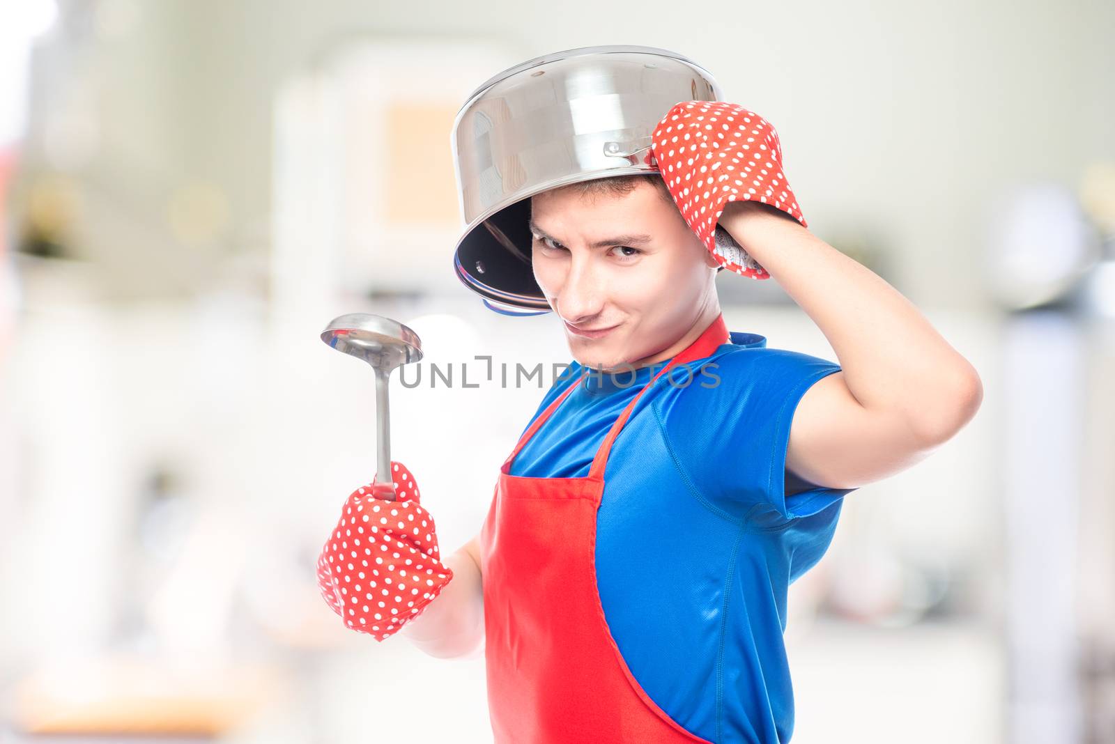 crazy man in an apron with a pan on his head posing in the kitchen