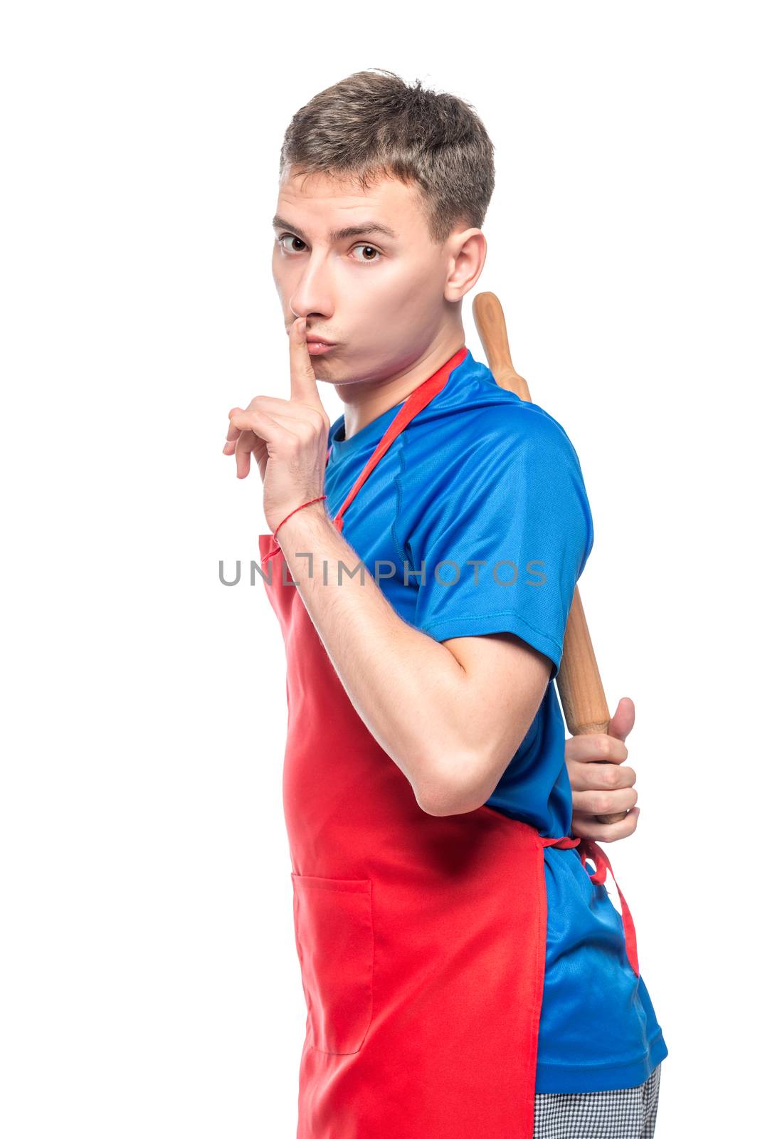 the chef in the apron hides the rolling pin behind his back, the gesture with the finger at the lips is quieter! Portrait is isolated on a white background