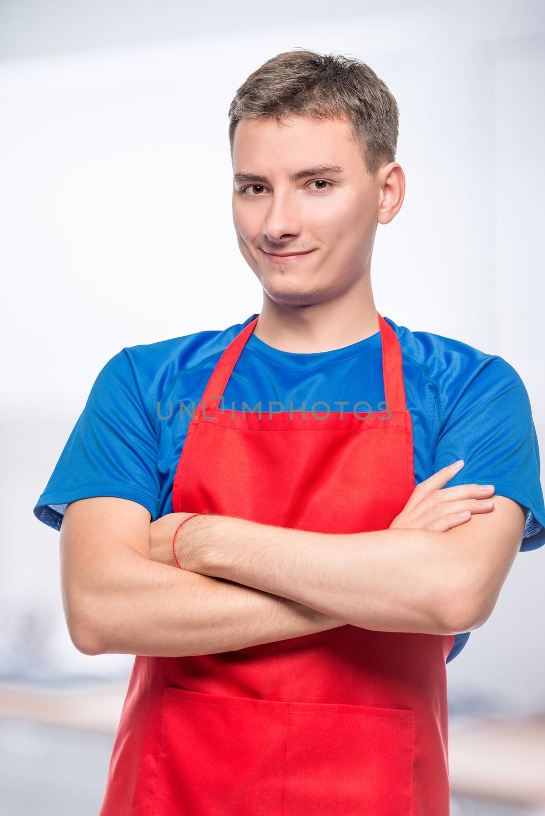 happy portrait of a man in a red apron on a gray background