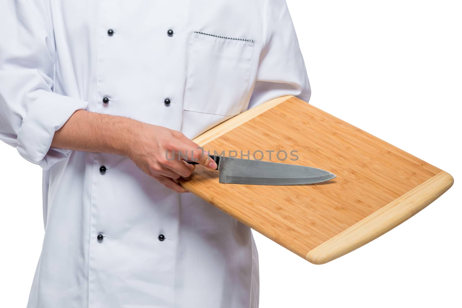 closeup of a wooden cutting board and a sharp knife in the hands of the chef