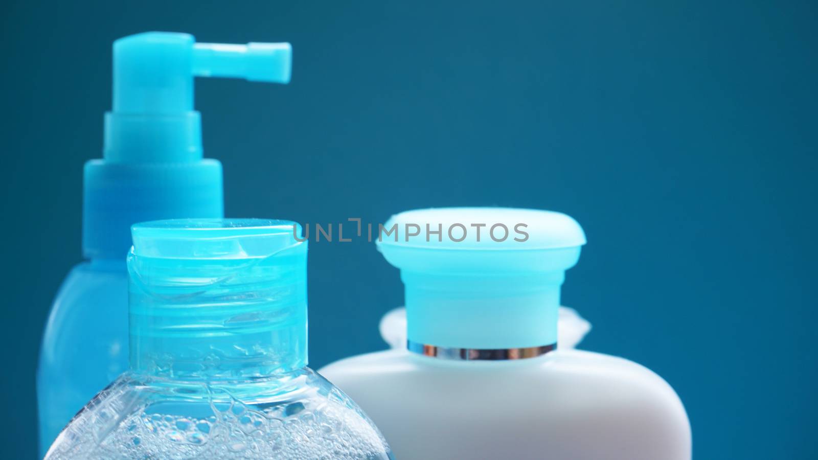 Blue cosmetic tube on blue background. Blank plastic container, packaging design. Copy space photography.
