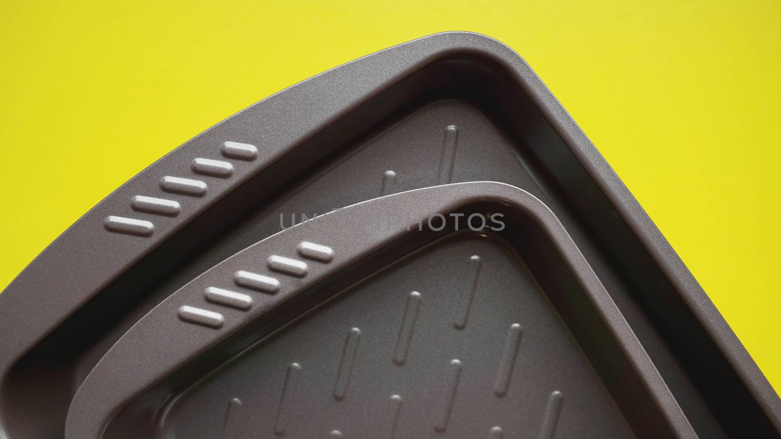 Empty baking tray. View from above on yellow background. Copy space photography.