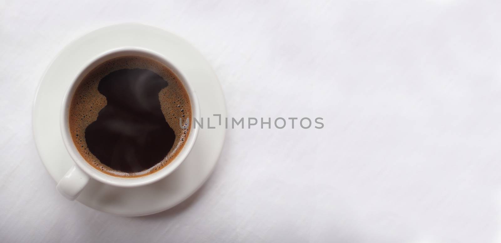 Black coffee in a coffee cup top view on background of White linen canvas , texture , tablecloth