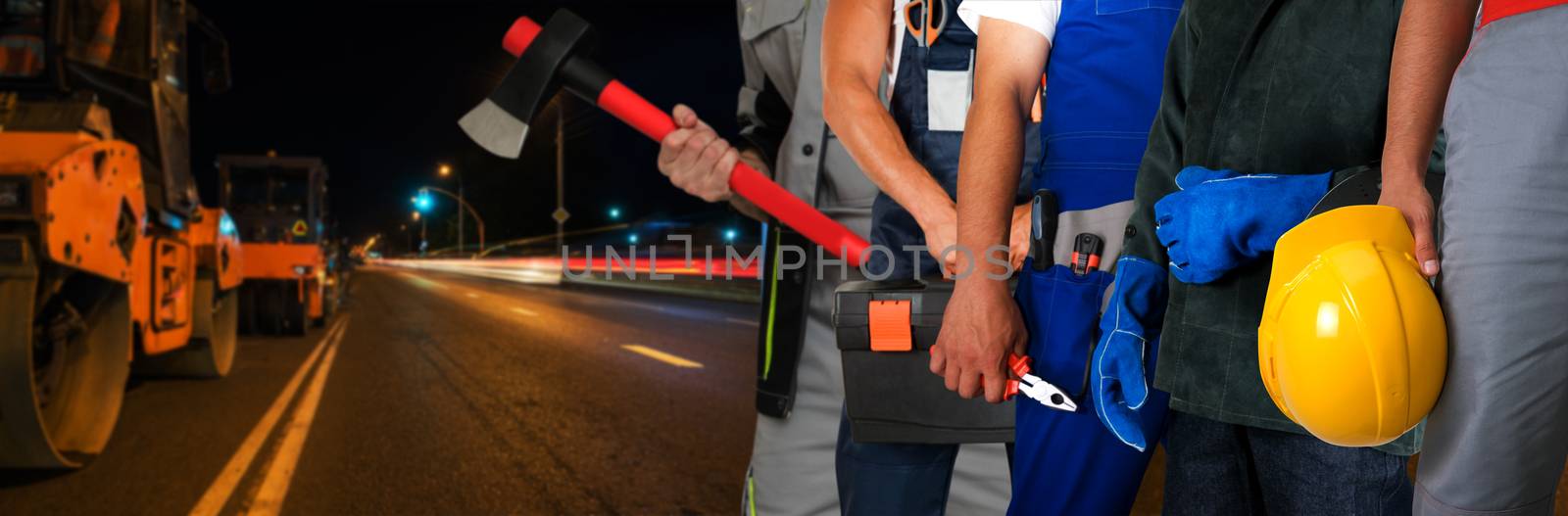 Builder workers with equipment repairing a road in night city