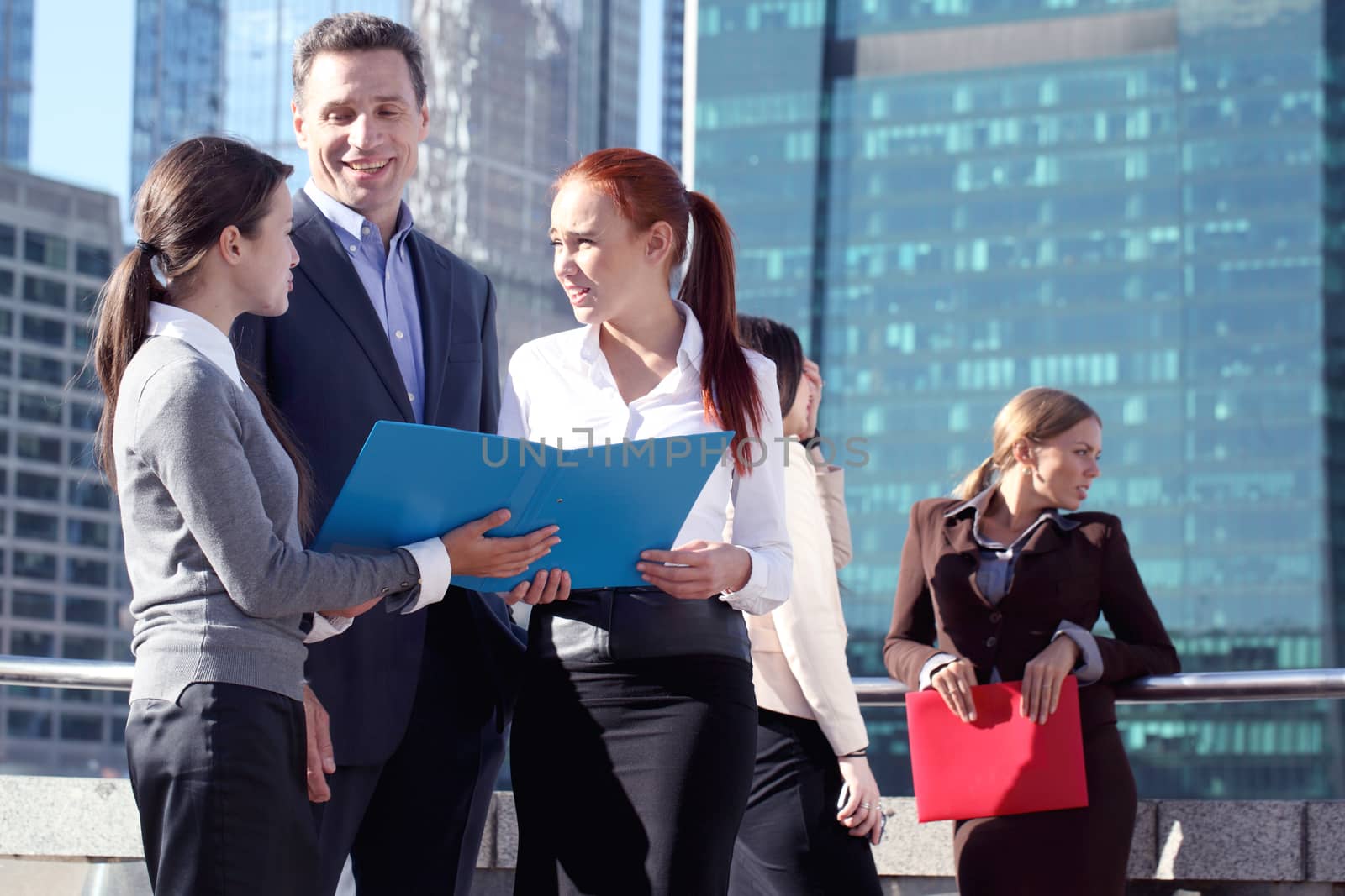 Portrait of business team outside office on skyscrapers background