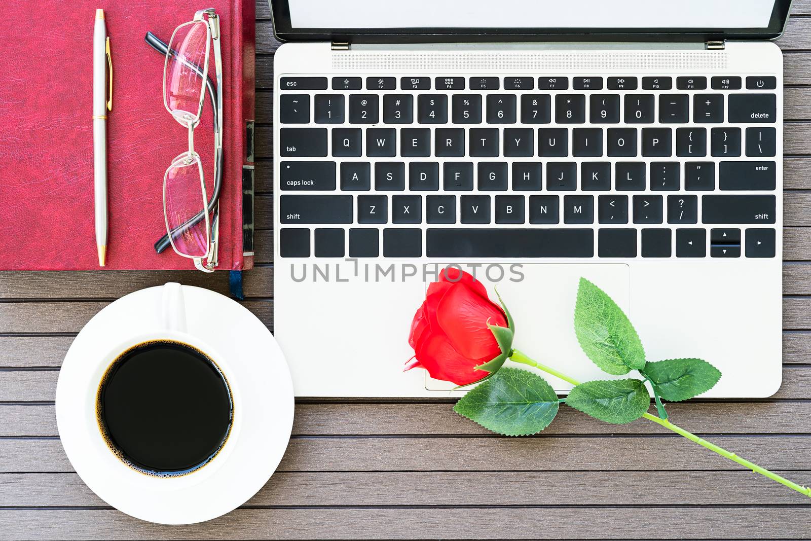 Office desk table with laptop,notebook, coffee cup,red rose by stoonn