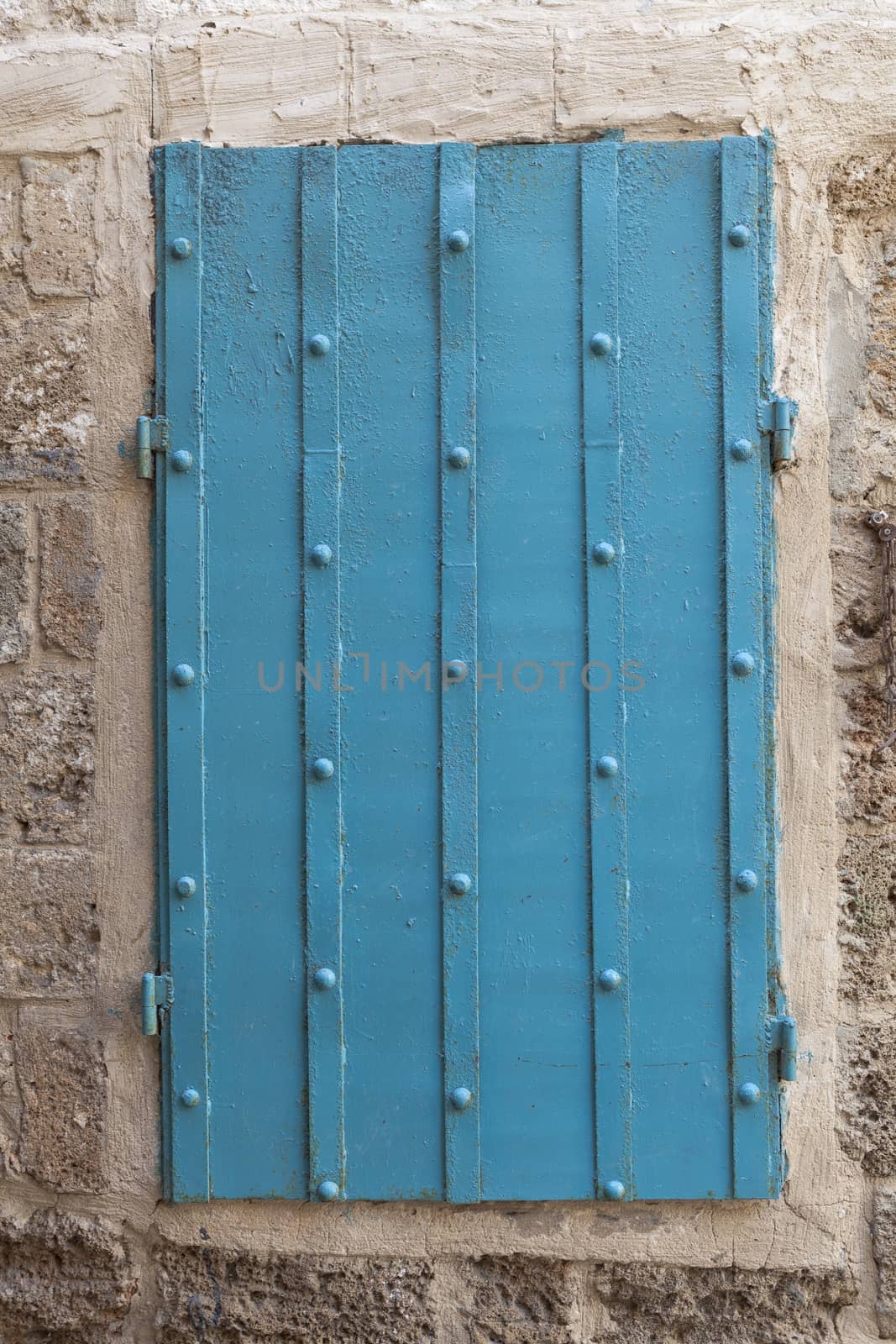 Old blue rusty metal window in a old wall