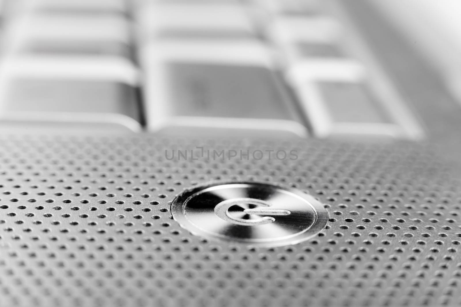 silver color laptop power button macro closeup  with holes grid arround