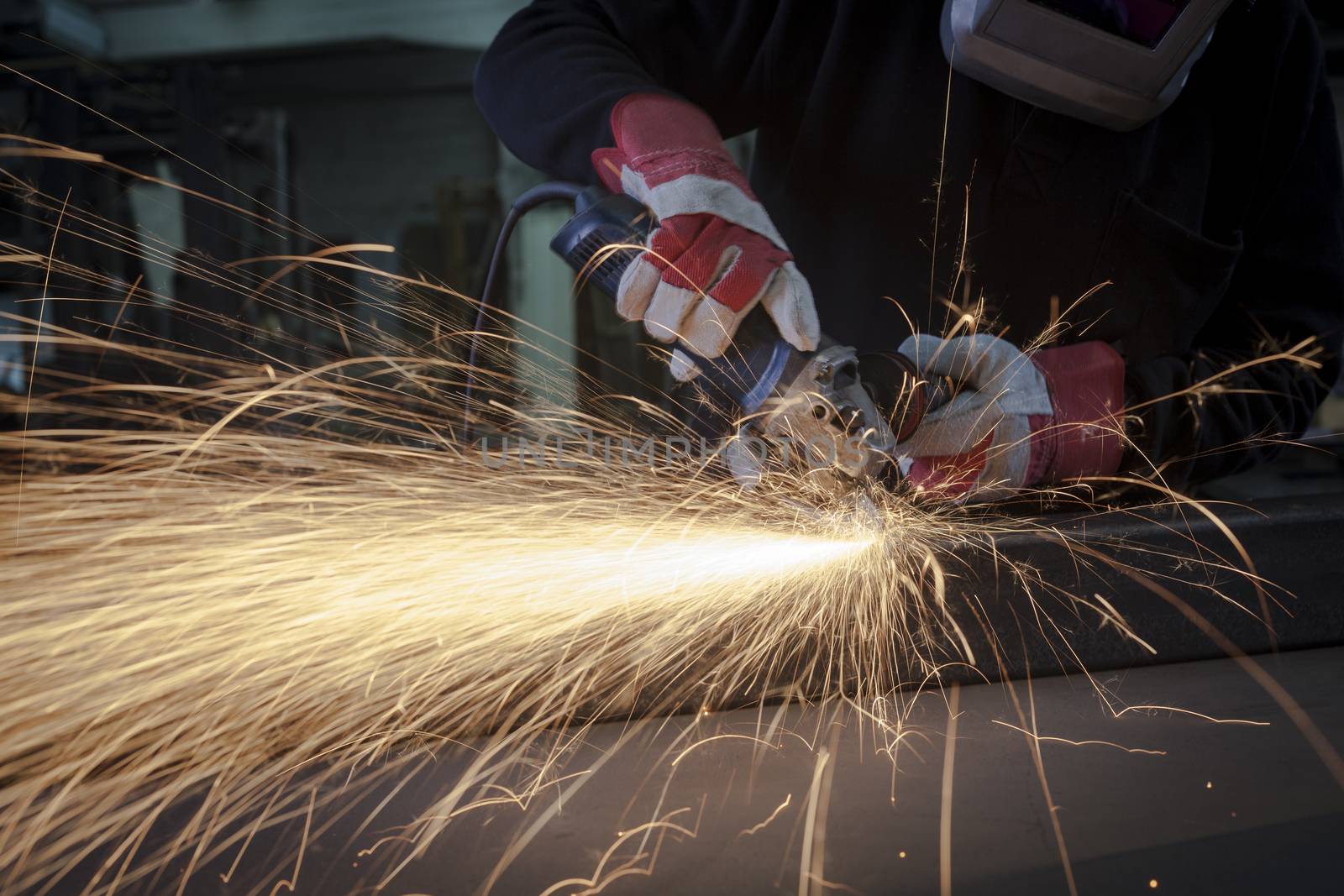 Grinding closeup with protection gloves and sparks