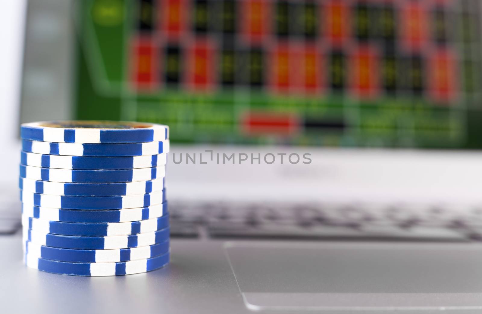 Casino chips with reflection on silver laoptop 