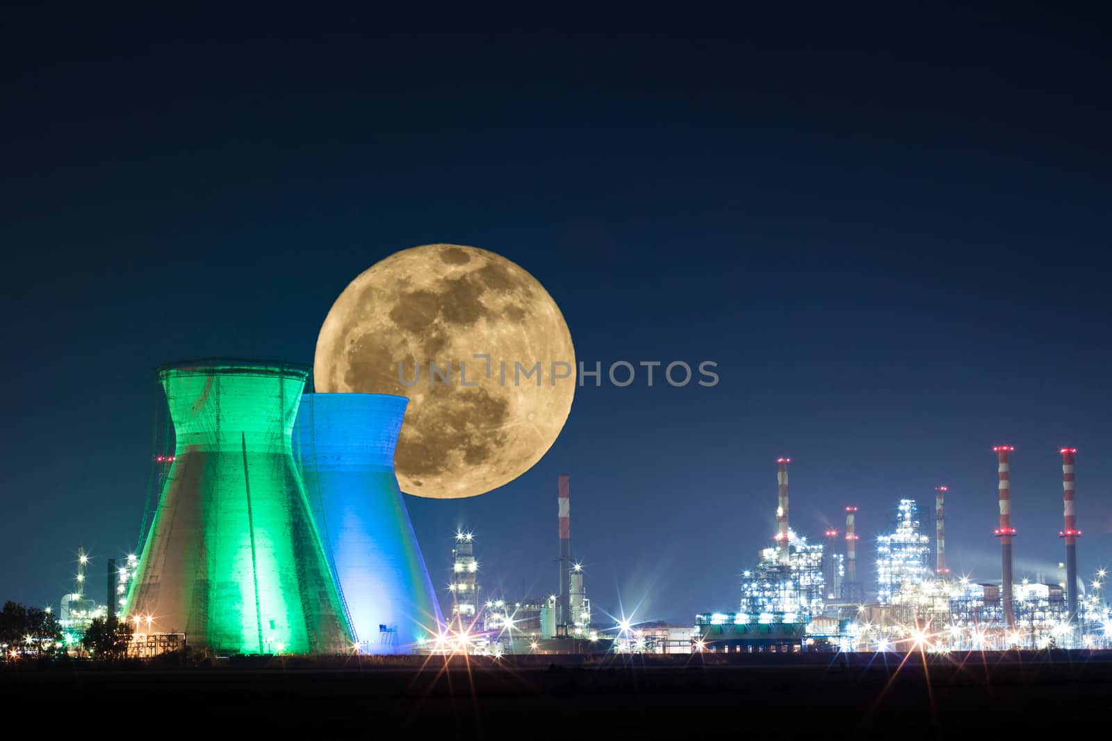 Oil refinery colored lights with moon at night
