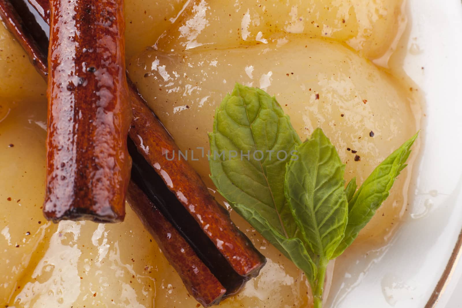 desert plate closeup with caramelized pears and green mint leaves
