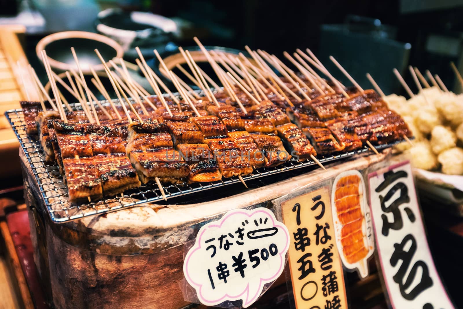 Grilled unagi or fresh water eel on sticks as street food at Nishiki market in Kyoto, Japan