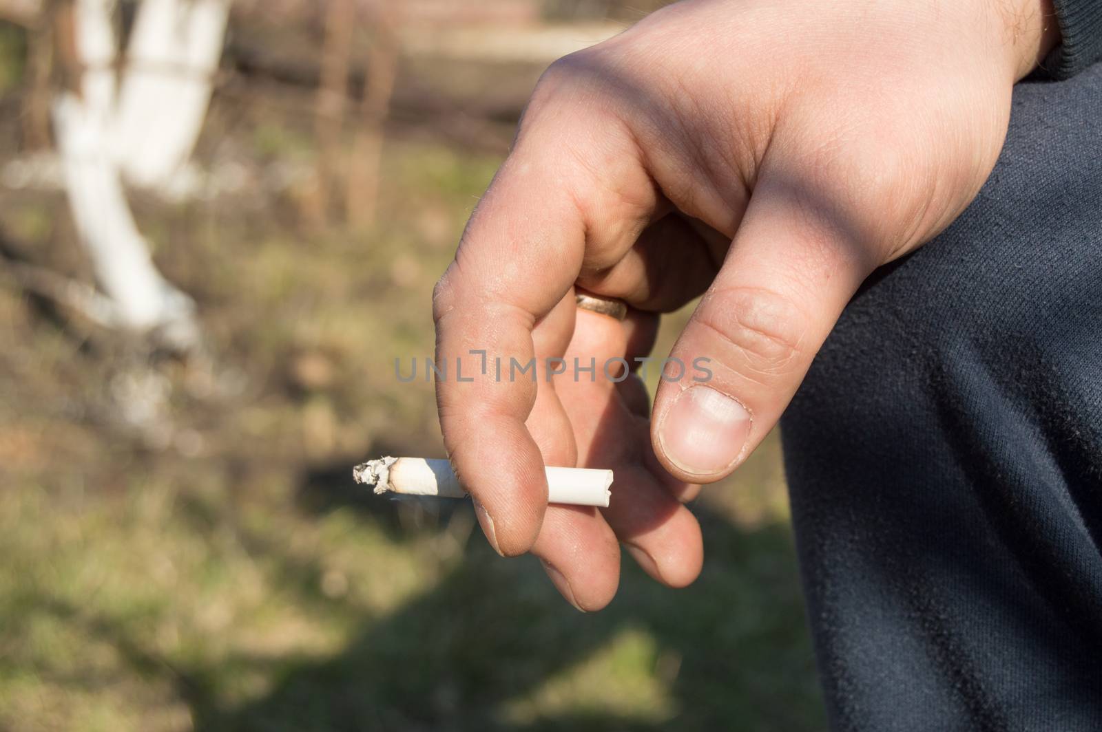 A young man holding a cigarette in his hand, sitting outdoors by claire_lucia
