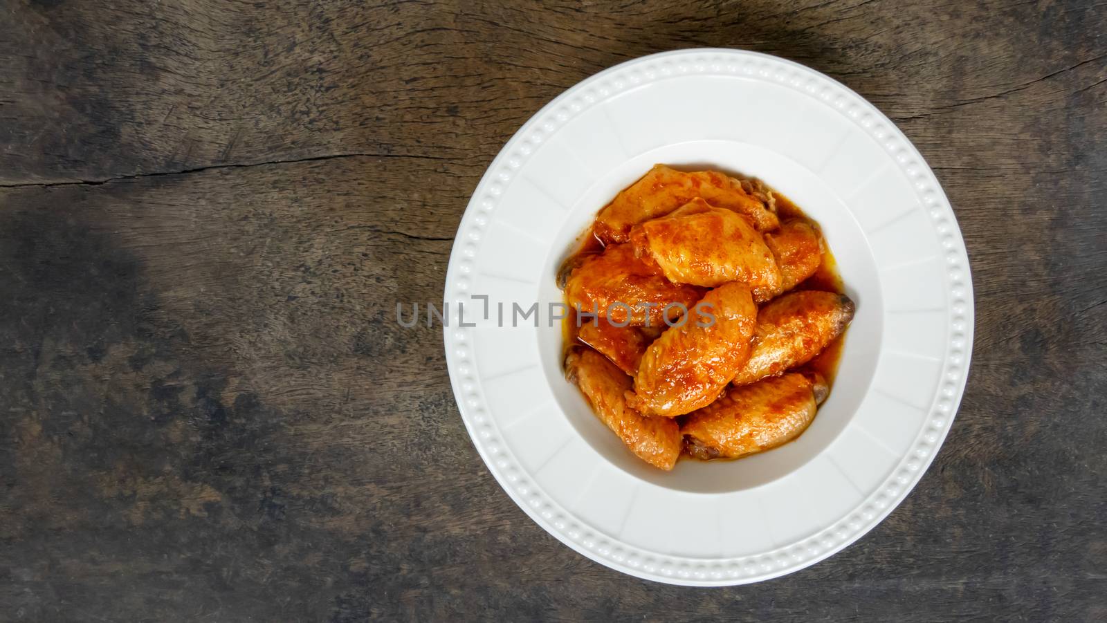 Baked chicken wings with spicy sauce. Food background with copy space. Top view